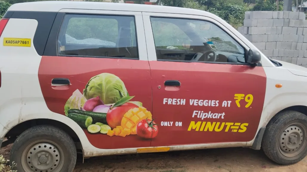 LetzRyd WagonR carrying a Flipkart Minutes ad for fresh vegetables on its side panels