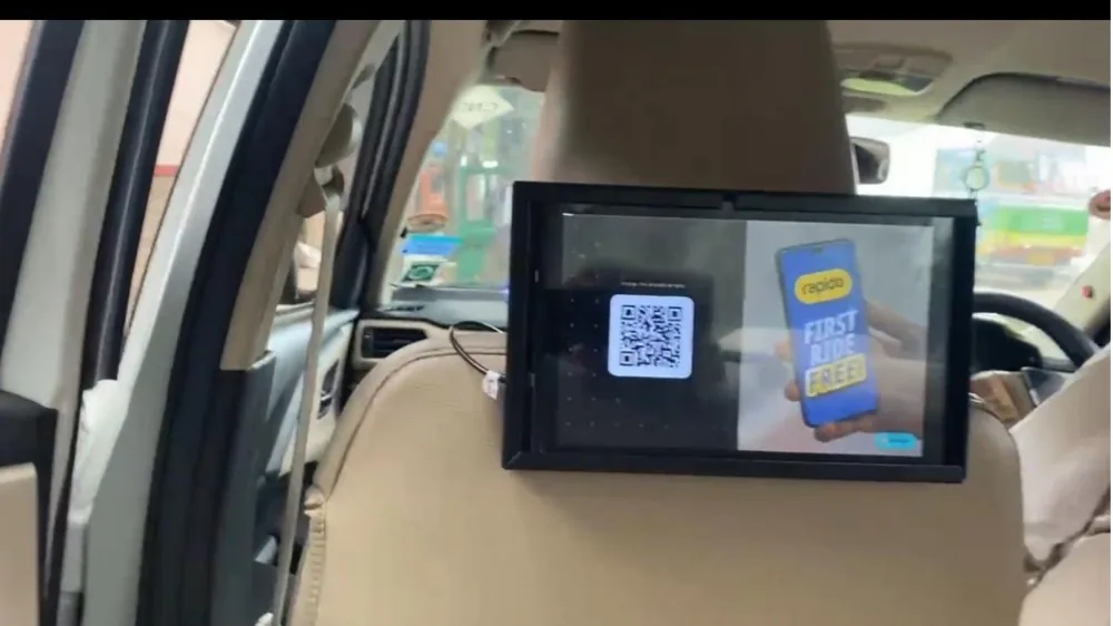 Seat-back tablet in a LetzRyd car showing a first ride free offer with a QR code