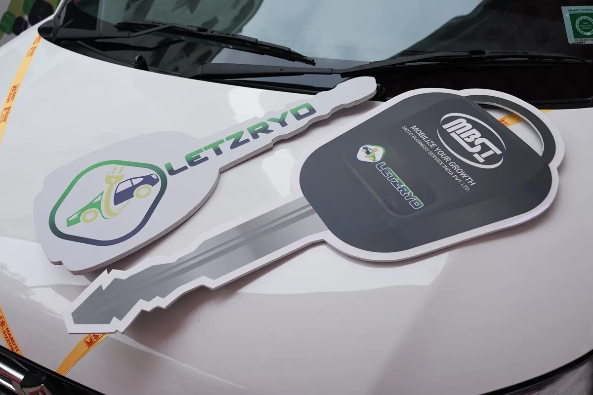 A driver holding the oversized LetzOwn key